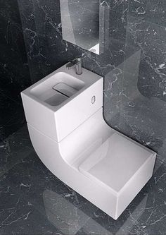 a white toilet sitting on top of a bathroom floor next to a wall mounted sink