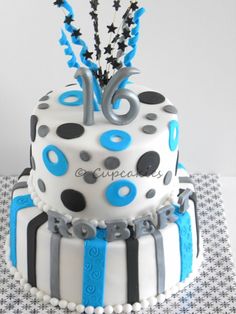 a white and blue birthday cake with black dots on it's top is decorated with stars