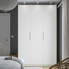 a bedroom with a bed and white cupboards next to a door on the wall