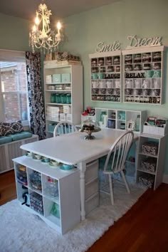 a white table and chairs in a room next to a book shelf with books on it