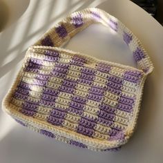 a crocheted purse sitting on top of a white table