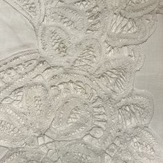 an image of white lace with flowers on it