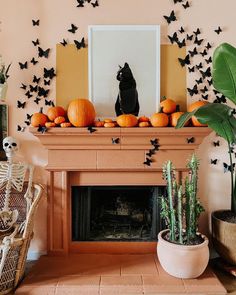 a living room decorated for halloween with pumpkins and bats on the fireplace mantel