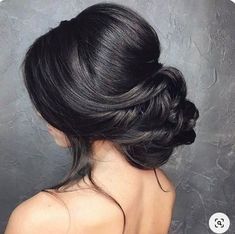 a woman with black hair in a low bun