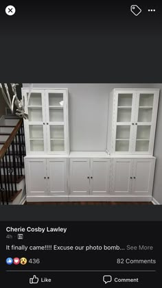 a white bookcase with glass doors and drawers in front of the stairs is shown