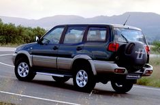 an suv is driving down the road with its back end up to the rear wheel