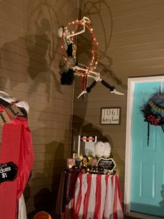 a halloween decoration is hanging on the wall next to a door and table with decorations