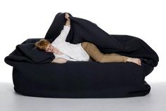 a young boy laying on top of a bean bag chair