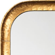 a gold framed mirror sitting on top of a table