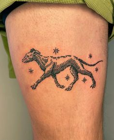 a man's thigh with a tattoo of a running dog