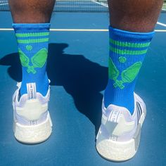 Show off your love for pickleball with these Pickleball Socks - Crossed Paddles - Blue/Green. These mid-calf socks feature a stylish crossed paddles design in a vibrant blue and green color scheme. The moisture-wicking material keeps your feet dry and comfortable during intense matches. With a cushioned footbed and supportive arch band, these socks provide the necessary support and comfort for a player's foot. Whether you're a beginner or a seasoned player, these pickleball socks are a great addition to your pickleball gear. Green Color Scheme, Green Color Schemes, Calf Socks, Paddles, Vibrant Blue, Pickleball, Blue And Green, Arch Support, Crew Socks