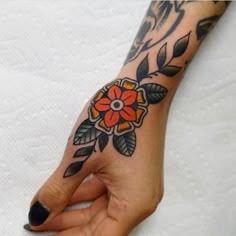 a woman's hand with a flower tattoo on it