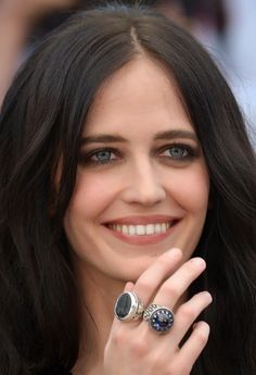 a close up of a person with a ring on her finger and smiling at the camera