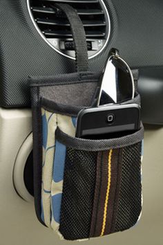 a cell phone in a pocket on the dashboard of a car with an air vent