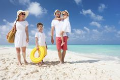 a family on the beach with an inflatable pool ring around their neck and wearing sun glasses