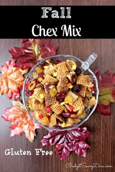 fall chex mix in a glass bowl on top of a wooden table with leaves