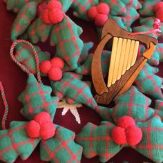 a green and red plaid christmas wreath with a wooden harp ornament on it