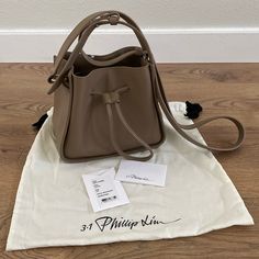 3.1 Phillip Lim Soleil Mini Bucket Drawstring Bag Color: Coffee (Light Brown/Taupe) Silver Hardware Style: As22-0132nbl Open Top With Drawstring Closure Approximately 7'h X 8'w X 4.25'd Approximately 18-21.5' Shoulder Strap Drop Leather Very Good Pre-Owned Condition (See Last Pic For A Slight Scuff) Comes With Dust Bag And Care Card Luxury Bucket Bag With Zipper Closure, Chic Brown Bucket Bag With Snap Closure, Brown Bucket Bag With Snap Closure, Brown Crossbody Bucket Bag With Zipper Closure, Brown Zipper Closure Bucket Bag, Drawstring Purse, Mini Bucket, 3.1 Phillip Lim, Phillip Lim