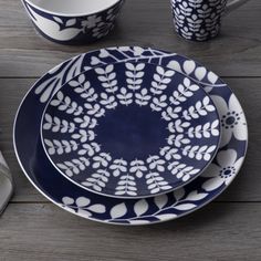 a blue and white dinnerware set on a wooden table