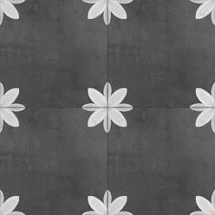 a black and white photo with flowers on it's side, in the middle of a tile floor