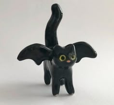 a black cat figurine with yellow eyes