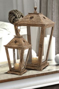 two wooden lanterns sitting on top of a table