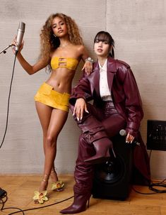 two people are posing for a photo in front of a wall with microphones and hair dryer