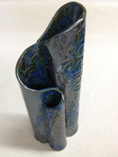 two blue vases sitting side by side on a white surface