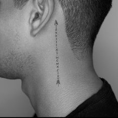 a man's neck with an arrow tattoo on the back of his left ear