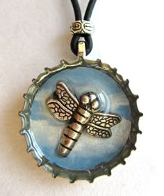 a glass bottle cap with a dragonfly on it