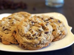 three chocolate chip cookies on a white plate