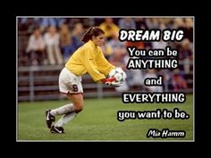 a woman in yellow shirt and white shorts holding a soccer ball with words on it