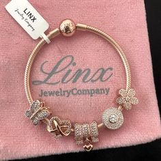 Linx Snake Chain Style Charm Bracelet In 18k Rose Gold Over 925 Sterling Silver, With A Ball Clasp. The Bracelet Is 3mm In Width And Available In Multiple Lengths, Including Child Size. This Bracelet Comes With 5 Linx Charms In 18k Rose Gold Over 925 Sterling Silver Charms. All Items Are New And Come In A Luxury Velvet Jewelry Pouch. *Bracelet And Charms Are Superior Quality. Luxury Rose Gold Jewelry With Sparkling Stones, Pink Bracelets With Diamond Accents For Gift, Pink Bracelets With Diamond Accents As A Gift, Fine Jewelry Rose Gold Cubic Zirconia Chain Bracelet, Rose Gold Cubic Zirconia Chain Bracelet Fine Jewelry, Rose Gold Cubic Zirconia Chain Bracelet, Pink Cubic Zirconia Jewelry With Charms, Luxury Rose Gold Jewelry With Charms, Luxury Rose Gold Bracelets With Sparkling Stones