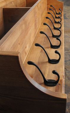 a row of black handles sitting on top of a wooden bench