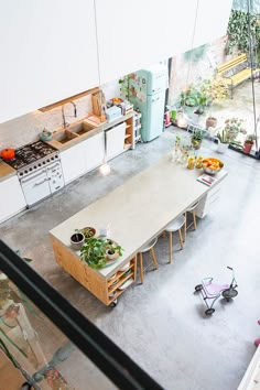 an overhead view of a kitchen and dining room with plants on the counter top, potted planters in pots