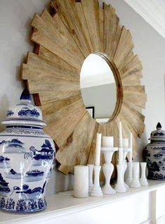 a mirror and vases are sitting on a mantel