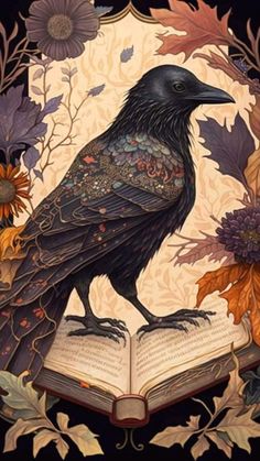 a black bird sitting on top of an open book with leaves and flowers around it