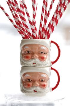 two santa mugs with candy canes sticking out of them