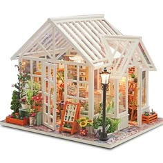 a doll house with furniture and flowers in the front yard is lit up at night