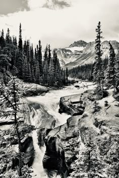 a black and white photo of a mountain stream