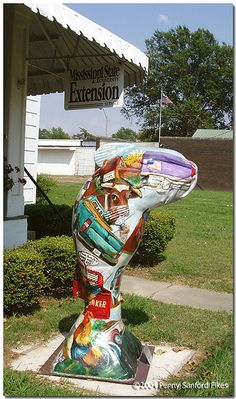 a sculpture of a man's head is in front of the mississippi state extension