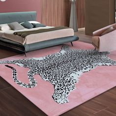 a leopard print rug is on the floor in front of a bed and two chairs