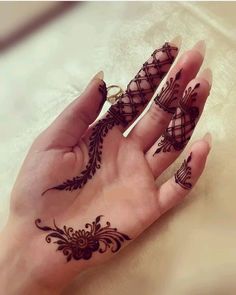 a woman's hand with henna tattoos on it