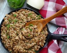 a skillet filled with food sitting on top of a red and white checkered table cloth