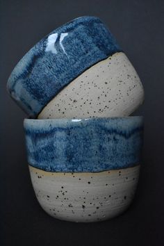 two blue and white bowls sitting next to each other