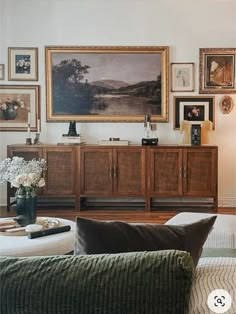 a living room filled with furniture and pictures on the wall