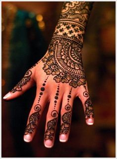 a woman's hand with henna tattoos on it