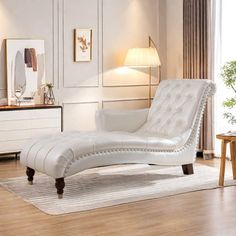 a white chaise lounge chair sitting on top of a rug in a living room