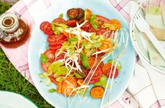 a blue plate topped with lots of veggies next to a jar of sauce