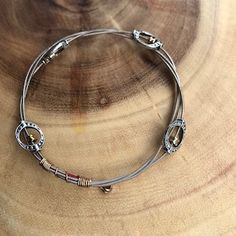 a silver bracelet sitting on top of a wooden table